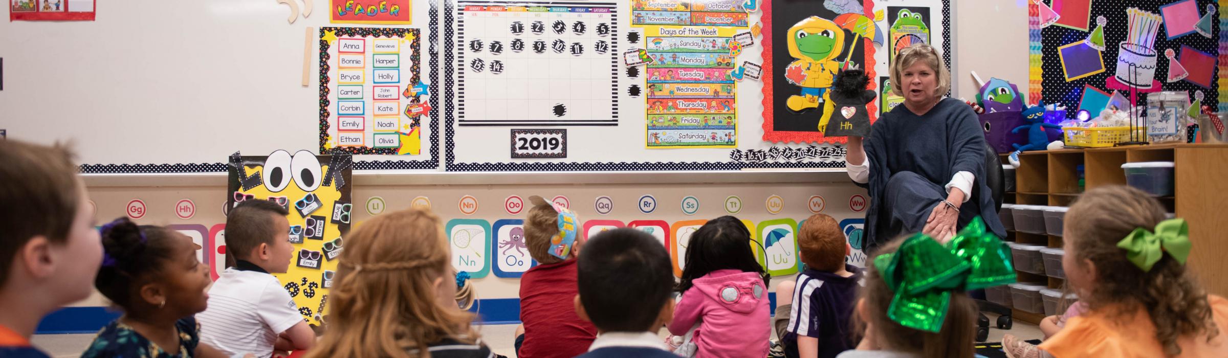 Picture of a teacher telling a story to a group of children.
